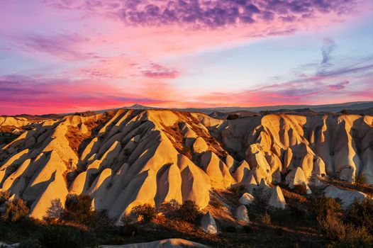 Vivid sunrise of rock formations shaped by a morning light - seen from above in Cappadocia, Turkey