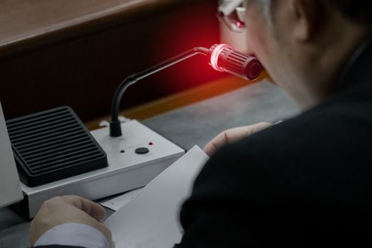 Elderly business man turn microphone on ready to speak up