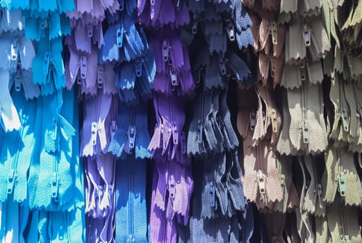 Detailed close up view on samples of zippers in different colors found at a fabrics market.