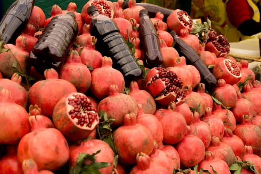 Ripe red pomegranates on the market. Cut pomegranates, herbs, juice