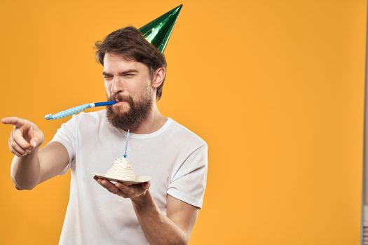 A bearded man with a cake and in a cap celebrating his birthday. High quality photo