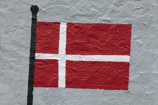 Childish style drawing, of the flag of Denmark, painted on a wall.