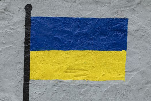 Childish style drawing, of the flag of Ukraine, painted on a wall.