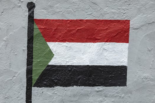 Childish style drawing, of the flag of Sudan, painted on a wall.