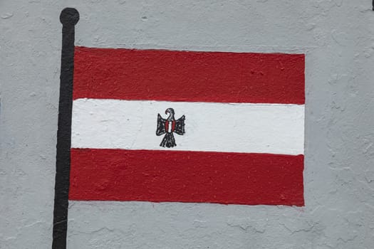 Childish style drawing, of the flag of Austria, painted on a wall.