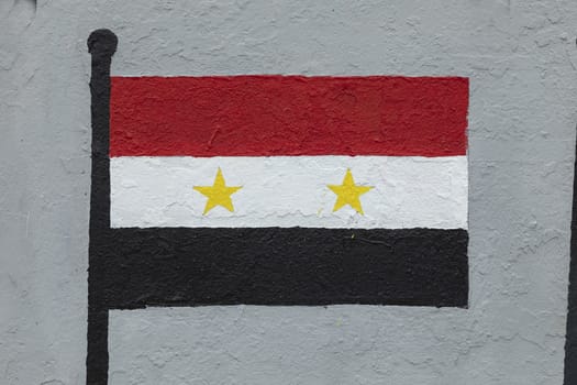 Childish style drawing, of the flag of Syria, painted on a wall.