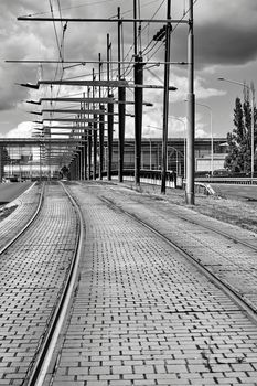 Tram tracks and electric traction on the viaduct in the city of Poznan in Poland, black and white