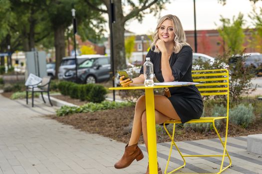 A gorgeous blonde model poses outdoors in her fall clothes