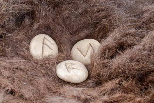 Stone runes on a fur. Futhark viking alphabet. Close up photo of Norse runes.