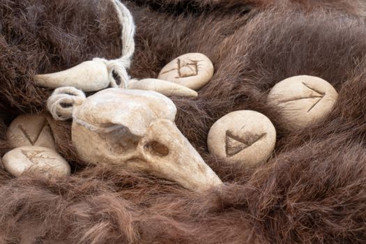 Stone runes on a fur. Futhark viking alphabet. Close up photo of Norse runes.