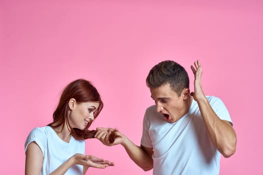 enamored man and woman hugging each other on a pink background cropped with Copy Space family portrait. High quality photo