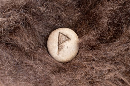 Wunjo Nordic stone rune on fur. Letter Wyn of the Viking alphabet.