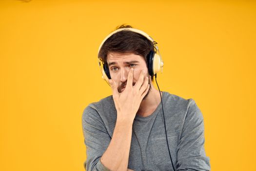 Man with headphones music lifestyle lifestyle technology yellow background. High quality photo