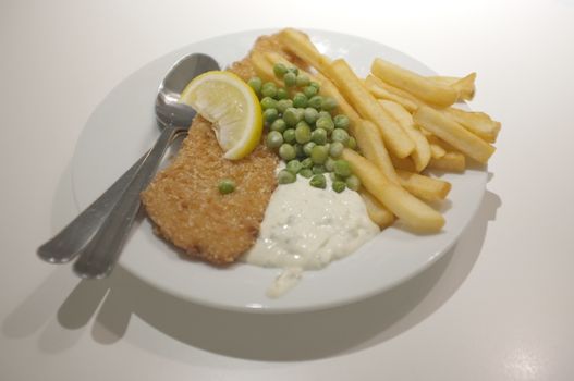 Fish and chips on a dish .