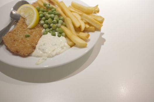 Fish and chips on a dish .