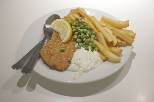 Fish and chips on a dish .