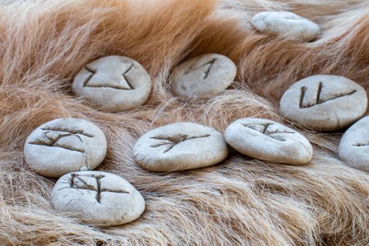 Stone runes on a fur. Futhark viking alphabet. Close up photo of Norse runes.