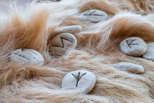 Stone runes on a fur. Futhark viking alphabet. Close up photo of Norse runes.