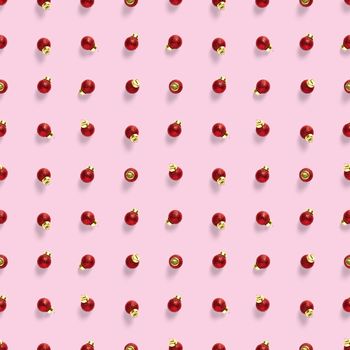 Seamless pattern with red Christmas decorations on pink background. Christmas red ornaments Seamless pattern. Christmas abstract background made from balls.