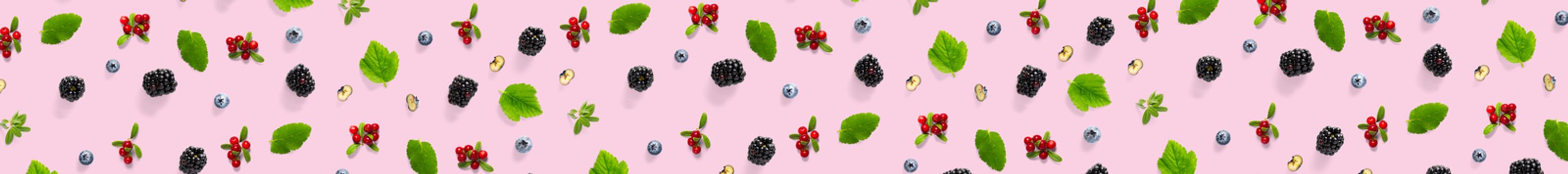 Creative set of wild berries, blackberry, blueberry, lingonberry and bramble. modern banner background on pink backdrop made from autumn forest wild berries. Forest berries mix