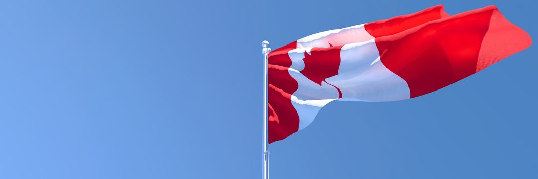 3D rendering of the national flag of Canada waving in the wind against a blue sky