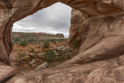 Desert view through the Broken Bow Arch, Utah.