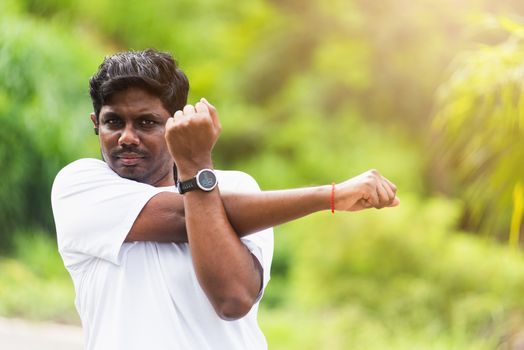 Close up Asian young sport runner black man wear watch he body warming up arms muscles before running at the outdoor street health park, healthy exercise Injury from workout concept