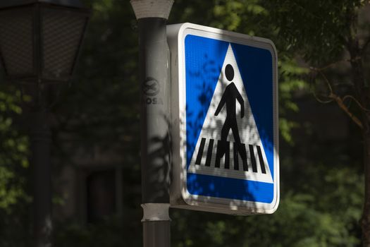 Madrid, Spain - May 18, 2020: Traffic signaling, warning of a pedestrian zone with zebra crossing for people, in the Retiro district.