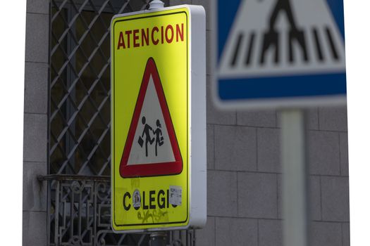 Madrid, Spain - May 18, 2020: Traffic signaling, warning of a pedestrian school zone with a zebra crossing for young children, in the Retiro district.