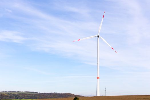 The windmill on a field with blue sky