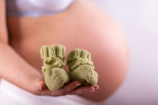 A belly of a pregnant woman, she is waiting for a miracle