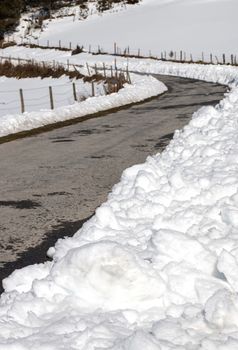 Mountain road with snow accumulated on the sides by the snowplow