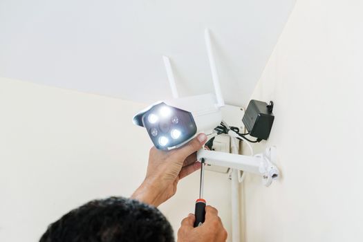 Technicians are installing wireless CCTV cameras on the walls of the house for security purposes.