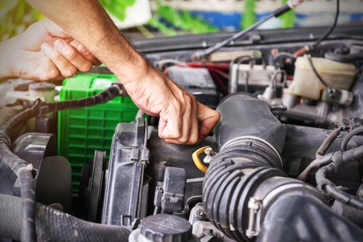 Cars mechanic is closing the engine oil lid after adding the oil to the engine to the level, Automotive industry and garage concepts.
