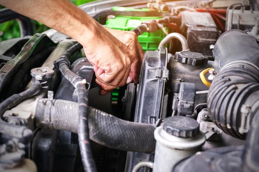 Cars mechanic is checking the cooling fans of a car, the automotive industry and the garage concept.