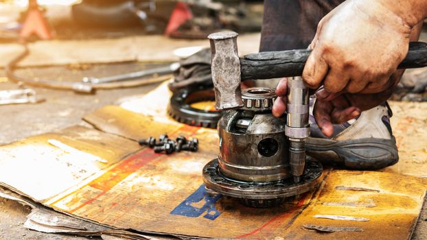 Technicians are using the tools to disassemble the gears of the drive shaft of cars to make replacement parts and repair.