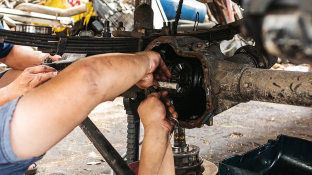 Technicians are helping to assemble the car power steering gearbox.