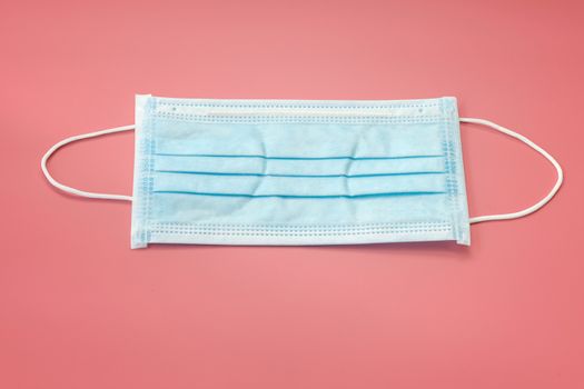 Sanitary napkin mask for preventing spreading and respiratory infections isolated on red pastel background, Stop Coronavirus Covid-19 concept.