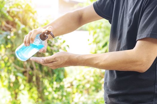 A man is cleaning his hands with alcohol gel to prevent Corona virus Covid-19 infection.