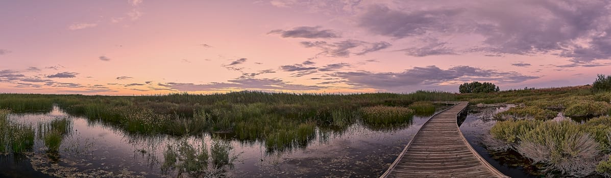 Wooden walkway over the lake in the rain, reflections, dusk, panorama