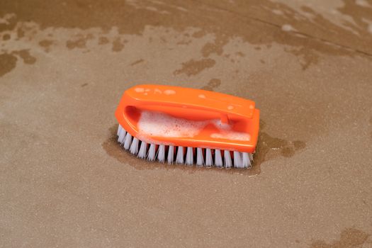 An orange plastic polishing pad for cleaning floors, walls, or general equipment.