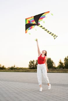 Active lifestyle. Happiness concept. Happy young woman running with a kite in a park at sunset