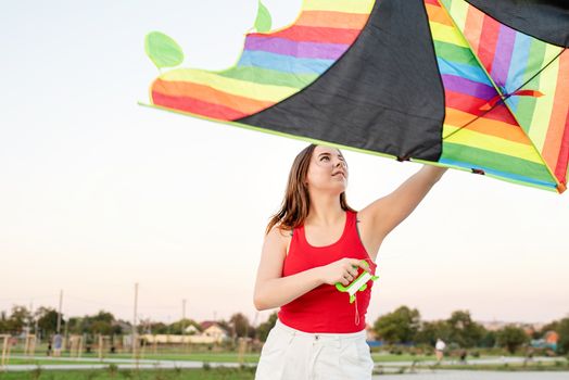 Active lifestyle. Happiness concept. Happy young woman running with a kite in a park at sunset