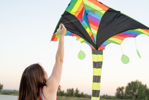 Active lifestyle. Happiness concept. Happy young woman running with a kite in a park at sunset