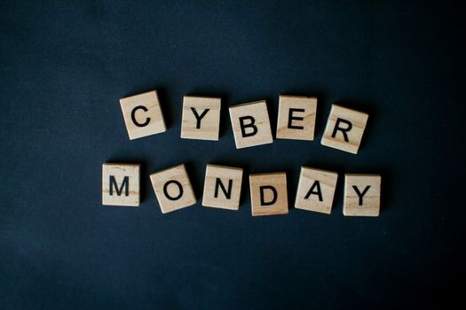 The inscription cyber monday from wooden blocks on a black background