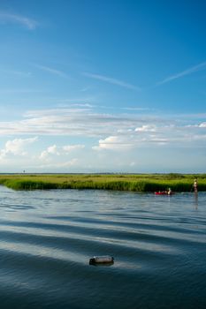 Women on a Kayak and a Canoe Slowly Riding Through the Bay With Gorgeous Greenery and a Clear Blue Sy Behind Them