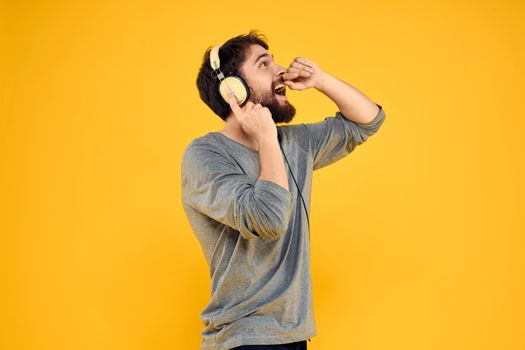 Man with headphones music lifestyle lifestyle technology yellow background. High quality photo