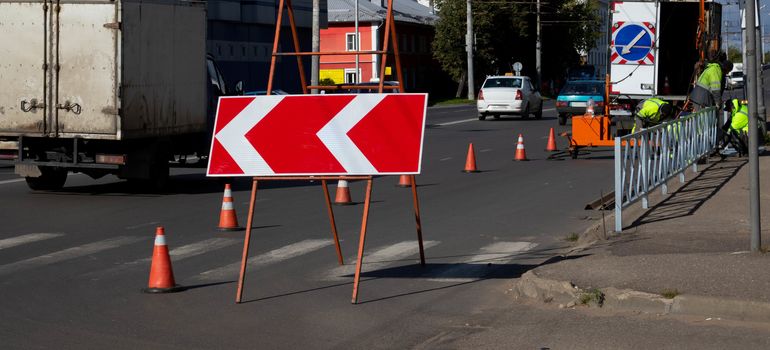 A large road sign on the road indicates the path, road works, detour of a dangerous section of road, repair of the roadway