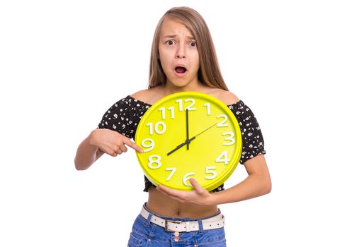 Surprised Teen Girl holding Big Clock, isolated on white background. Portrait of teenager showing big clock with Stress. Shocked Child back to school.