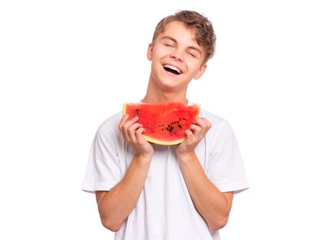 Portrait of teen boy eating ripe juicy watermelon and smiling. Cute caucasian young teenager with slice healthy watermelon. Funny happy child wearing white t-shirt, isolated on white background.